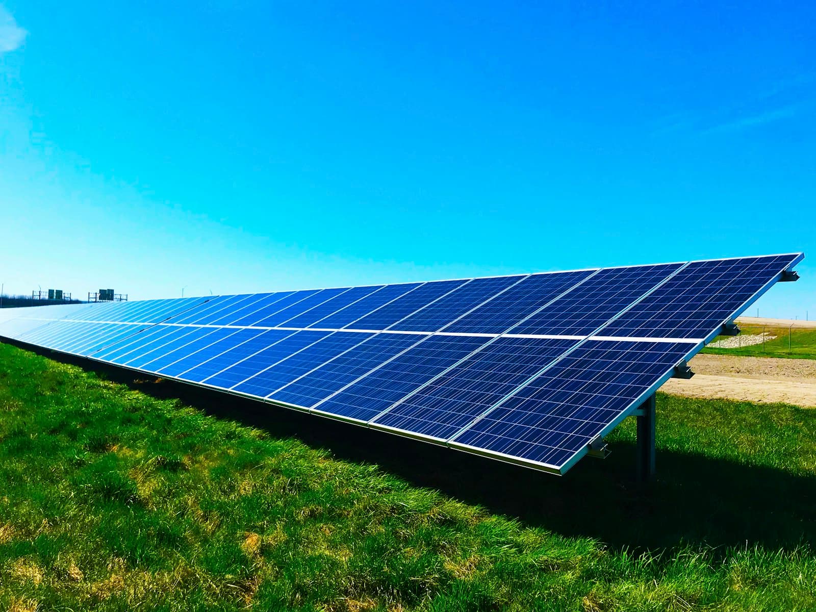 A large solar array under a bright blue sky, the kind of generation a home battery stores for later use