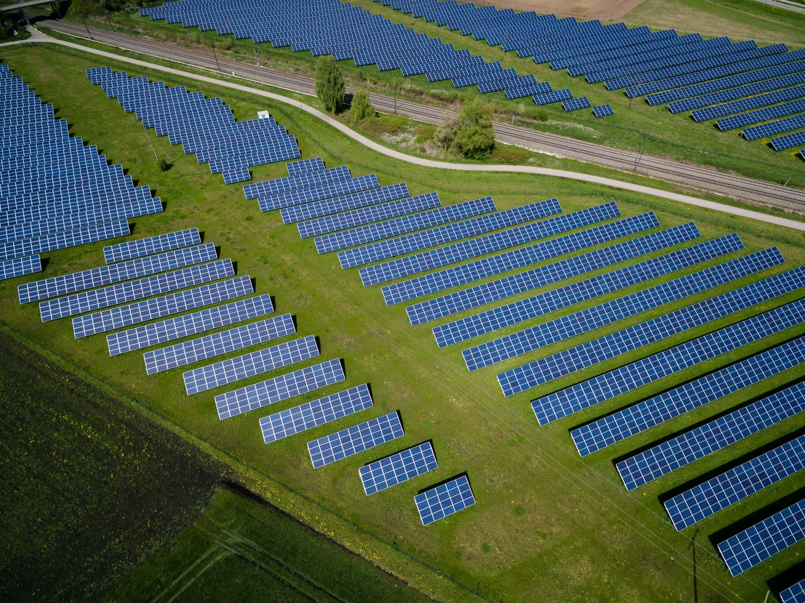 Aerial view of a large solar installation, panels arranged in neat rows